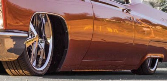 The side of a lowered red classic car.