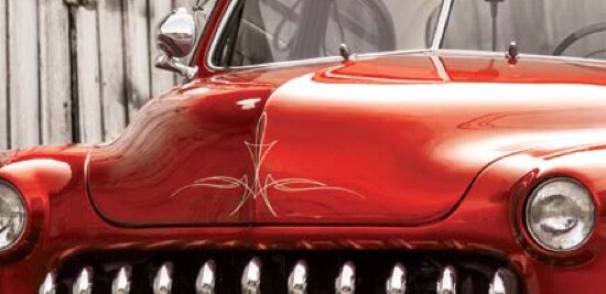 The front of a classic red truck.